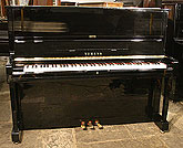 A Yamaha U1 upright piano with a black case and polyester finish. A Yamaha U1 upright piano with a black case and polyester finish.