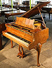 A Strohbech baby grand piano with a polished, walnut case. A Strohbech baby grand piano with a polished, walnut case.