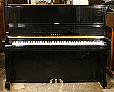 A Yamaha U1 upright piano with a black case and polyester finish. A Yamaha U1 upright piano with a black case and polyester finish.