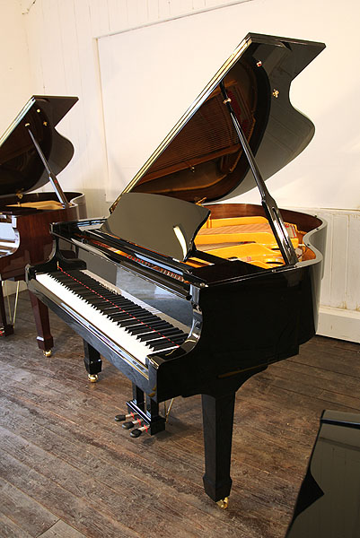 Brand new Steinhoven Model 160 baby grand piano with a black case and brass fittings.  Piano has an eighty-eight note keyboard and a three-pedal piano lyre.