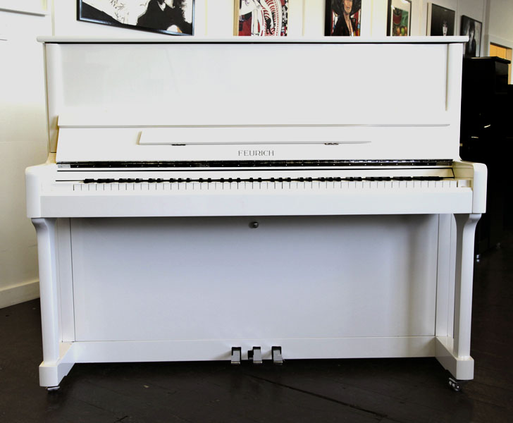 Brand new, Feurich Model 122 upright piano with a white case and chrome fittings. Piano has an eighty-eight note keyboard and three pedals 