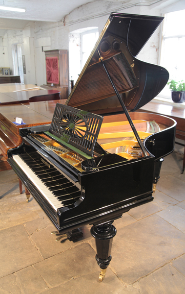 A restored, 1899, Bechstein Model A grand piano with a black case, cut-out music desk and turned legs