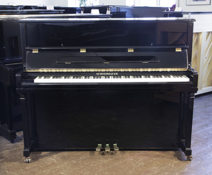 A Schiedmayer E-118 Upright Piano For Sale with a Black Case and Brass Fittings Piano has an eighty-eight note keyboard and three pedals.