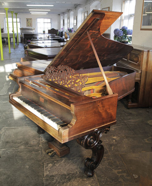 An antique, Steinway Style 2 grand piano with a rosewood case, filigree music desk and ornately carved, scroll foot legs and lyre