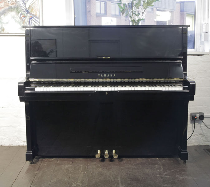 A 1980, Yamaha U2 upright piano with a black case and polyester finish. Piano has an eighty-eight note keyboard and three pedals.