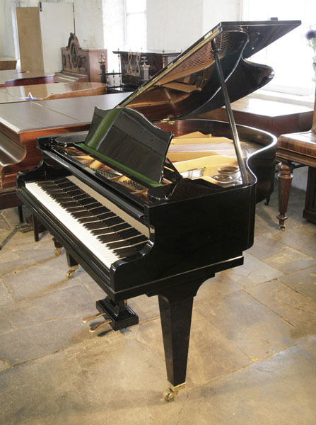 A pre-owned, Bechstein Model S baby grand piano with a black case and tapered legs. 