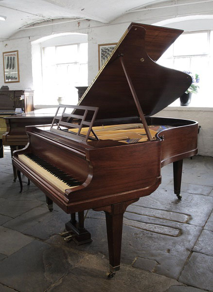 A 1923, Bluthner grand piano for sale with a rosewood case, openwork music desk and square, tapered legs.