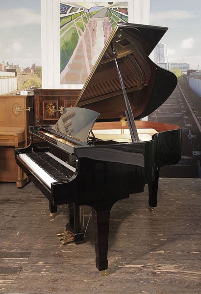 A 2008, Boston GP156 baby grand piano for sale with a black case and spade legs. Piano has an eighty-eight note keyboard and a three-pedal lyre.