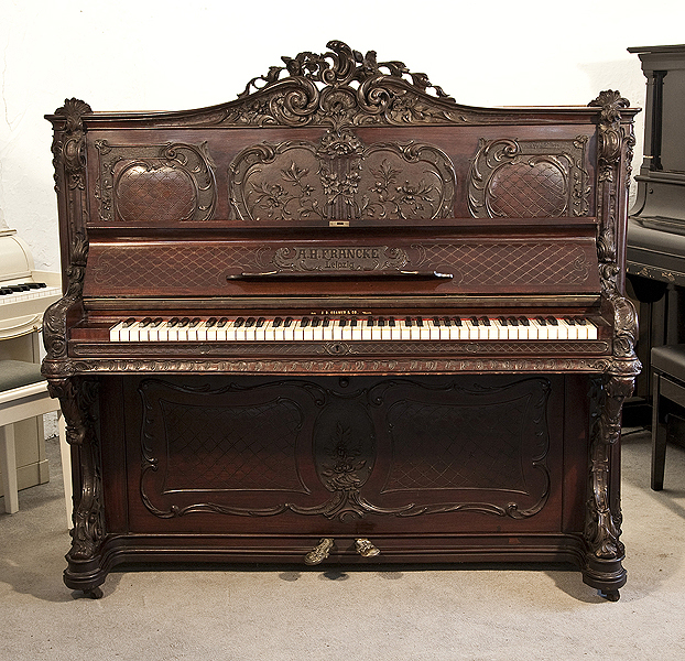 Rococo style, Francke upright piano for sale with an ornately carved, mahogany case and reverse scroll legs. Piano has an eighty-five keyboard and two pedals.