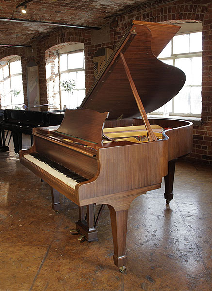 Restored 1961, Steinway Model M grand piano with a satin, walnut case and spade legs. Piano has an eighty-eight note keyboard and a two-pedal lyre.