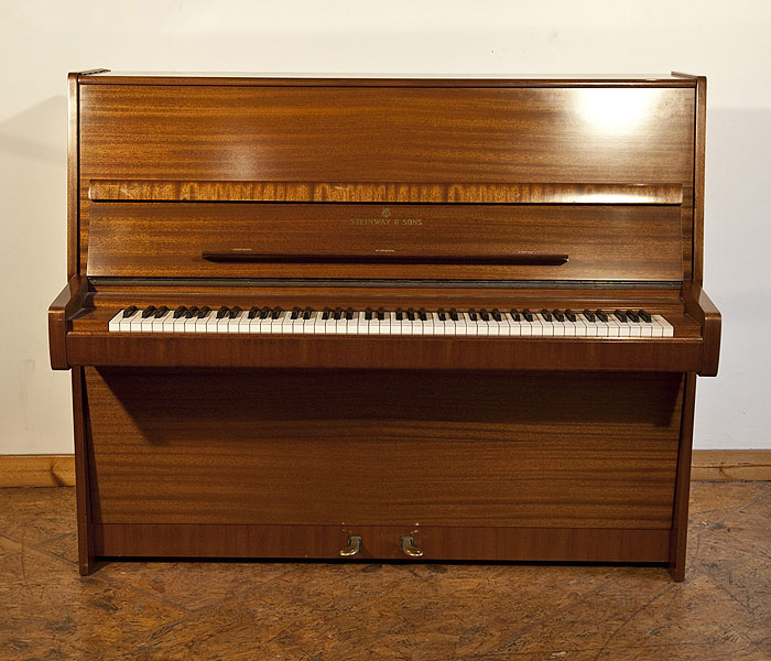 A 1975, Steinway Model V upright piano with a polished, mahogany case. Piano has an eighty-eight note keyboard and two pedals. 