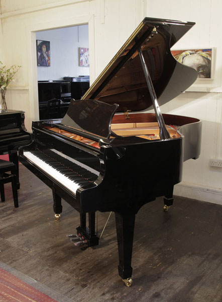 A brand new, Toyama TC-162 grand piano for sale with a black case and spade legs. Piano features a slow fall mechanism on the keyboard lid. Piano has an eighty-eight note keyboard and a three-pedal lyre.