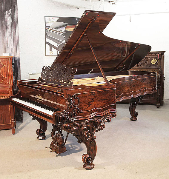 Rebuilt, 1874, Steinway & Sons Model D Centennial concert grand piano for sale with a rosewood case, filigree music desk and ornately carved, reverse scroll legs. Piano has an eighty-eight note keyboard and a two-pedal lyre.  