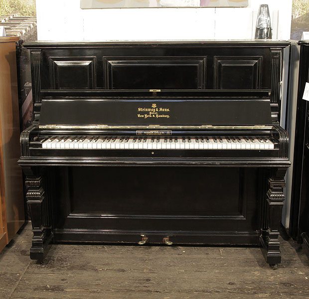 Antique, 1889, Steinway upright piano with a black case and square, tapered legs. Piano has an eighty-five note keyboard and two pedals.