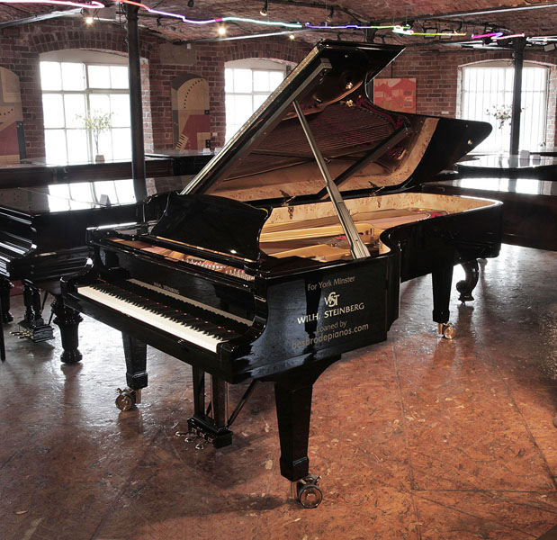 Brand new, Wilh Steinberg WS-D275 concert grand piano with a black case and brass fittings. Piano has an eighty-eight note keyboard and three-pedal lyre 