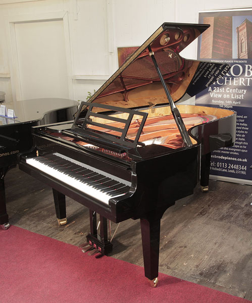 Brand new, Feurich model F218 Concert I grand piano with a black case and square tapered legs. Piano has an eighty-eight note keyboard and a three-pedal piano lyre.  