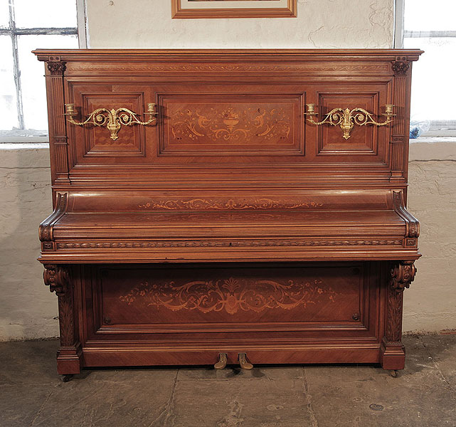 Albert Gast upright piano for sale with a quartered, walnut case and ornate, brass candlesticks. Entire cabinet inlaid with Neoclassical designs featuring scrolling acanthus, urns and flowers.  Piano has an eighty-eight note keyboard and two pedals