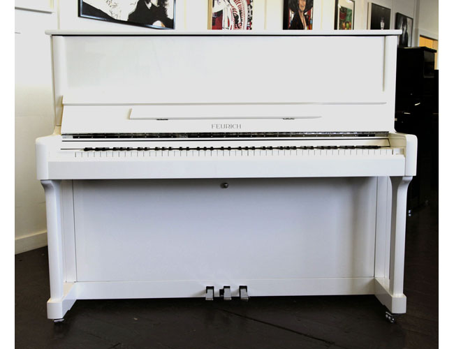 Brand new, Feurich Model 122 upright piano with a white case and chrome fittings. Piano has an eighty-eight note keyboard and three pedals.