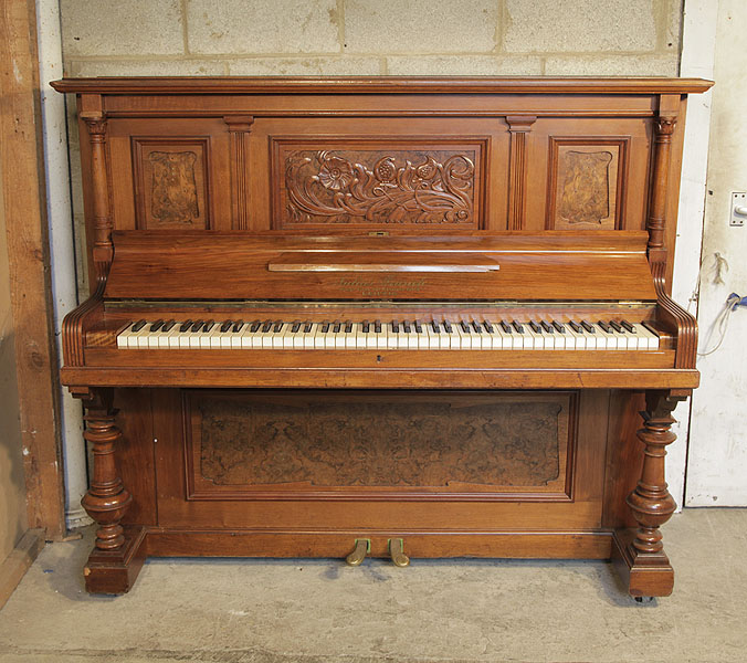 A 1903, Feurich upright piano with a walnut case, and Art Nouveau style carved front panel and cup and cover legs