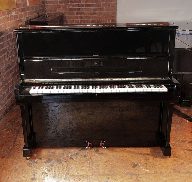 Reconditioned, 1986, Steinway Model V upright piano with a black case and brass fittings. Piano has an eighty-eight note keyboard and two pedals.