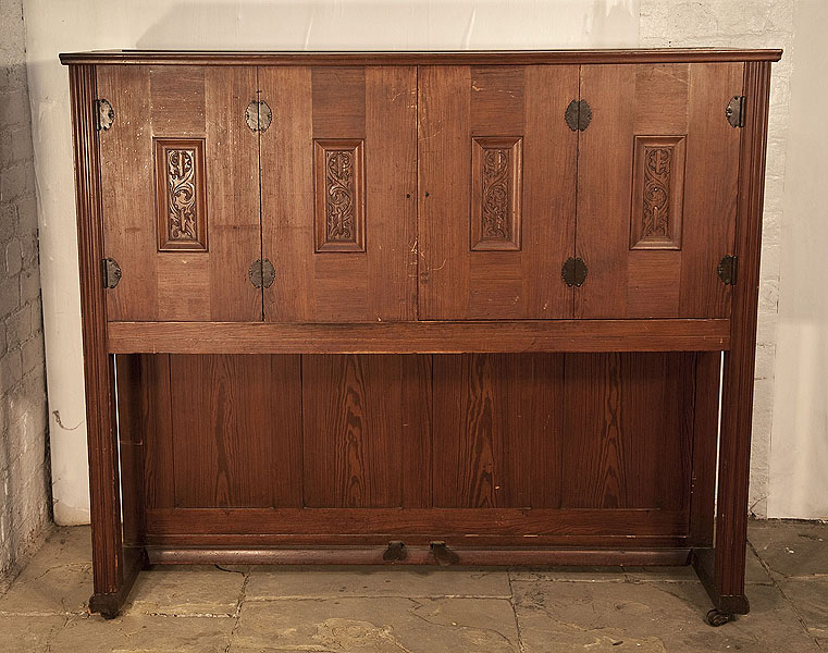 Mayer upright piano for sale with an Arts and Crafts style, pitch pine cabinet. Doors enclose the keyboard, music stand and candlesticks and feature carved panels of stylised foliage and decorative, scalloped hinges. Piano has an eighty-five note keyboard and two pedals. 