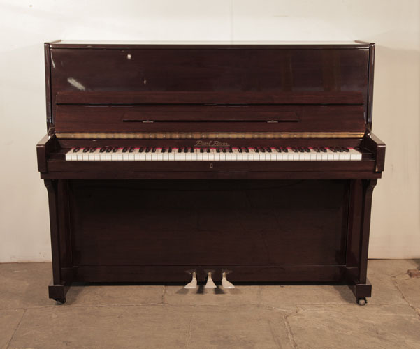 Pre-owned, 2001, Pearl River upright piano with a mahogany case and polyester finish. Piano has an eighty-eight note keyboard and and three pedals.  