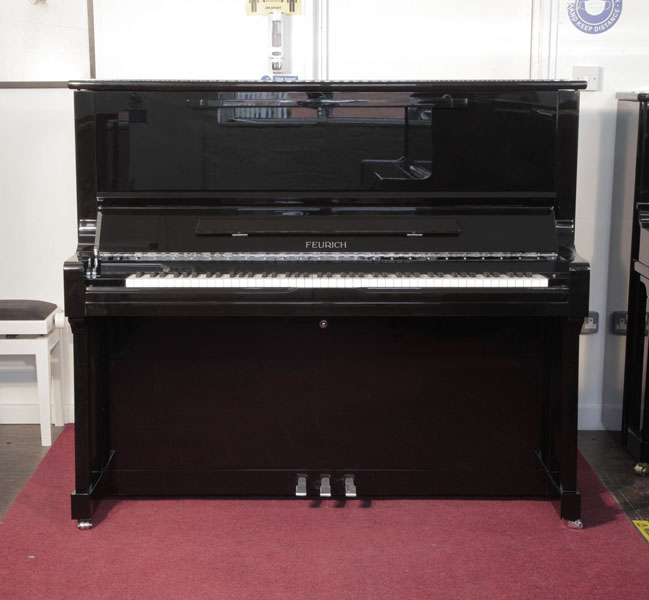 Brand new, Feurich Model 133 Concert upright piano with a black case and chrome fittings. Cabinet features and extendable LED strip light and a slow fall mechanism. Piano has an eighty-eight note keyboard and three pedals.