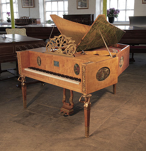 A 1918, Soren Jensen model D butterfly grand piano with a polished, maple case. Piano sits on three square, tapered legs with bronze female nude, caryatids adorning the top. Cabinet features hand-painted ovals by Danish artist Gudmund Hentze.