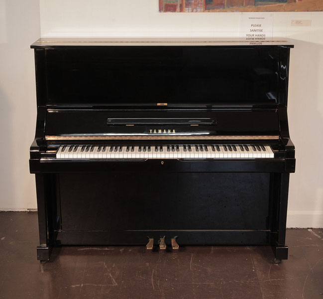 Reconditioned, 1979, Yamaha UX upright piano for sale with a black case and brass fittings. Piano has an eighty-eight note keyboard and three pedals. 
 