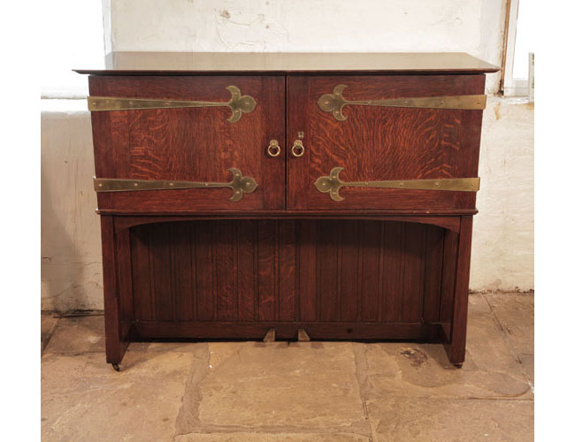 rts and Crafts, 1904, Broadwood 'Manxman' piano with an oak case and brass strap hinges. Cabinet resembles a chest on a stand and is reminiscent of an old strong box from the Elizabethan period. Cabinet entirely encloses the instrument. Designed by M. H. Baillie Scott