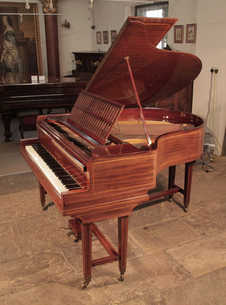 A 1910, Collard and Collard baby grand piano with a mahogany case and gate legs attached with a cross stretcher. Cabinet inlaid with satinwood stringing accents. Piano has an eighty-five note keyboard and a two-pedal lyre. 