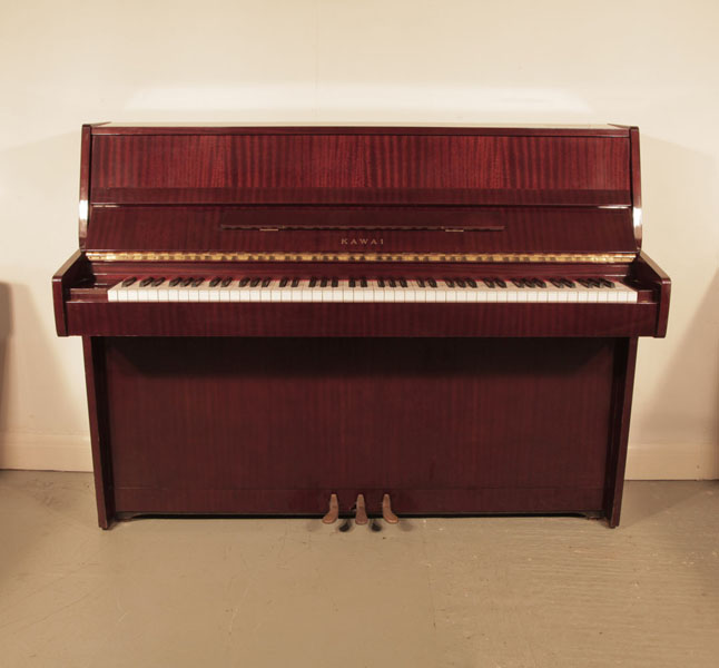 A 1982, Kawai CE7N upright piano for sale with a mahogany case and brass fittings. Piano has an eighty-eight note keyboard and three pedals.  