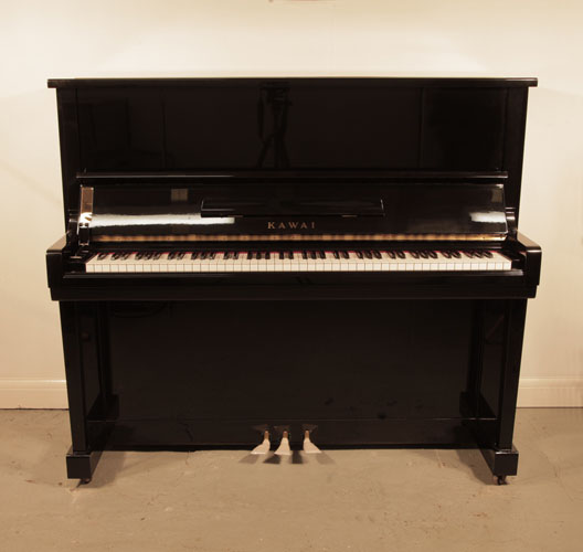 Piano for sale. Reconditioned, 1964, Kawai K20 upright piano with a black case and polyester finish. Piano has an eighty-eight note keyboard and three pedals.
