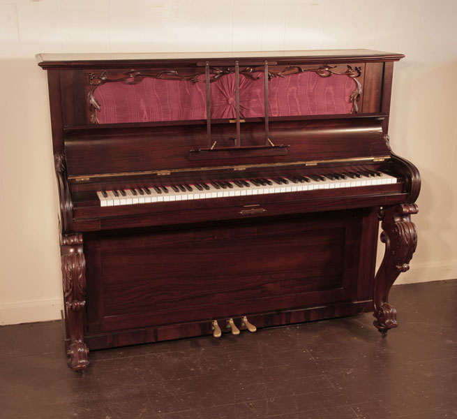 Reconditioned, Victorian upright piano with a rosewood case and carved, cabriole legs. Piano has an eighty-eight note keyboard and three pedals.