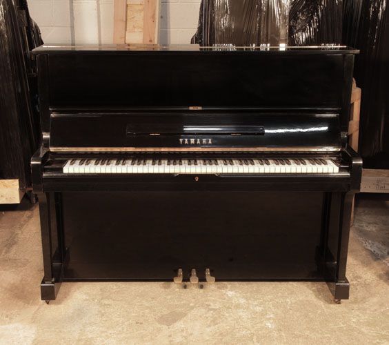  Reconditioned, 1973, Yamaha U1 upright piano with a black case and polyester finish. Piano has an eighty-eight note keyboard and three pedals. 