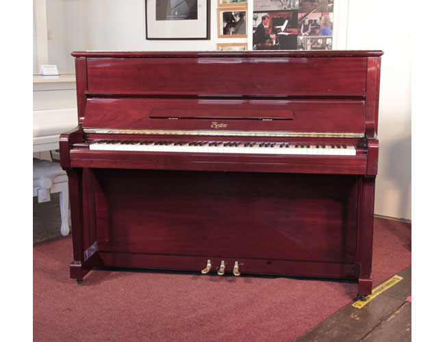 Reconditioned, 1999, Boston UP-118E upright piano for sale with a mahogany gloss case and brass fittings. Piano has an eighty-eight note keyboard and three pedals. 