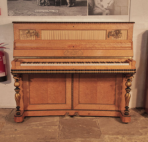 An 1860's, Chappell upright piano with a French style, bird's eye maple case. Cabinet features gilt and black accents. Piano has an eighty-five note keyboard and two pedals.  