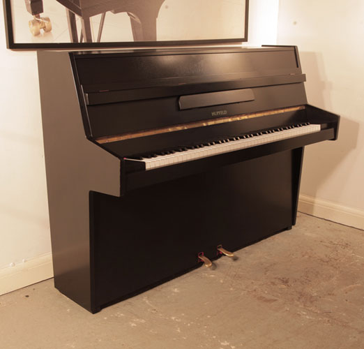 Reconditioned, 1970, Hupfeld  upright piano with a satin, black case and brass fittings.Piano has an eighty-five note keyboard and two pedals. 