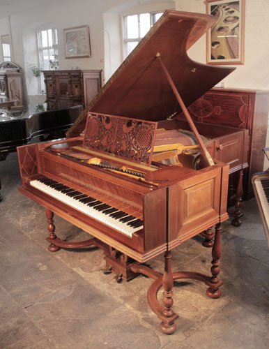 A 1912, Schiedmayer model 15 grand piano for sale with a harpsichord style mahogany cabinet with bevelled panels and boxwood and satinwood stringing accents. The music desk is in an openwork Arts and Crafts design. The eight baluster legs with bun feet are fixed to a serpentine cross stretcher. Piano has a traditional shaped two-pedal lyre. 