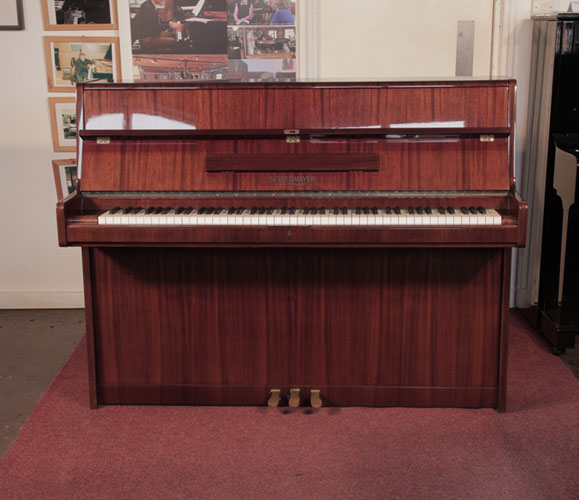 Reconditioned, 1972, Schiedmayer upright piano with a mahogany case and polyester finish. Piano has an eighty-eight note keyboard and three pedals.