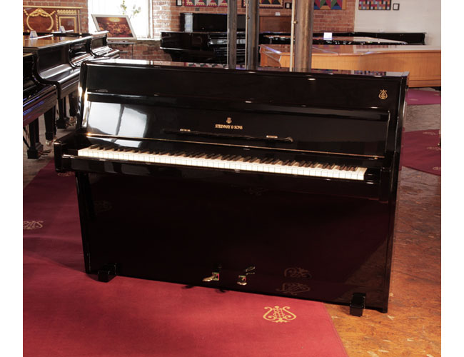 Reconditioned,  1960, Steinway Model F upright piano for sale with a black case and brass fittings.  Piano has an eighty-eight note keyboard and two pedals. 