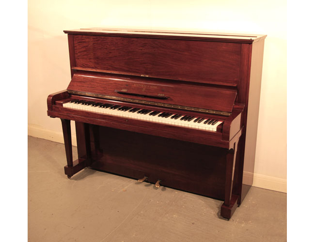 A 1936, Steinway Model V upright piano with a quartered, mahogany case and brass fittings . Piano has an eighty-eight note keyboard and two pedals.   