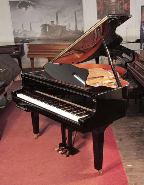 A 2014, Yamaha GB1 baby grand piano for sale with a black, gloss case and square, tapered legs. Piano has a fitted Disklavier DKC-800 player system. Piano has an eighty-eight note keyboard and a three-pedal lyre. 