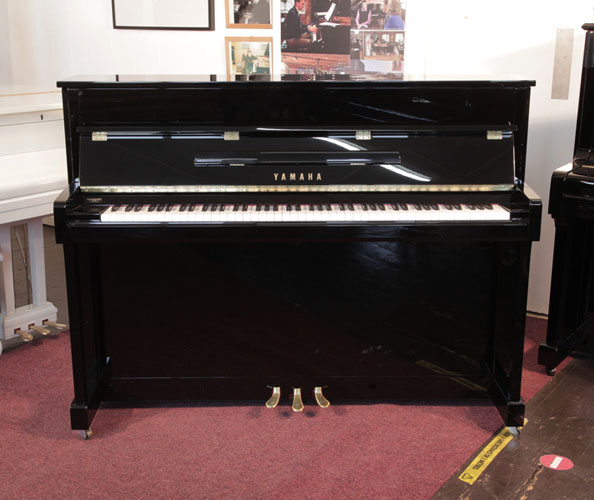 Pre-owned, 2022, Yamaha b2e PE upright piano with a gloss black case and brass fittings. Condition as new. Piano has an eighty-eight note keyboard and three pedals.