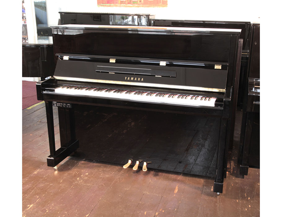 A 2020, Yamaha b3e PE-Silent upright piano with a black case and fitted Silent System. Piano has an eighty-eight note keyboard and three pedals. 