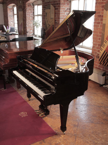 A 2000, Boston GP156 baby grand piano for sale with a black case and spade legs. Piano has an eighty-eight note keyboard and a three-pedal lyre.
