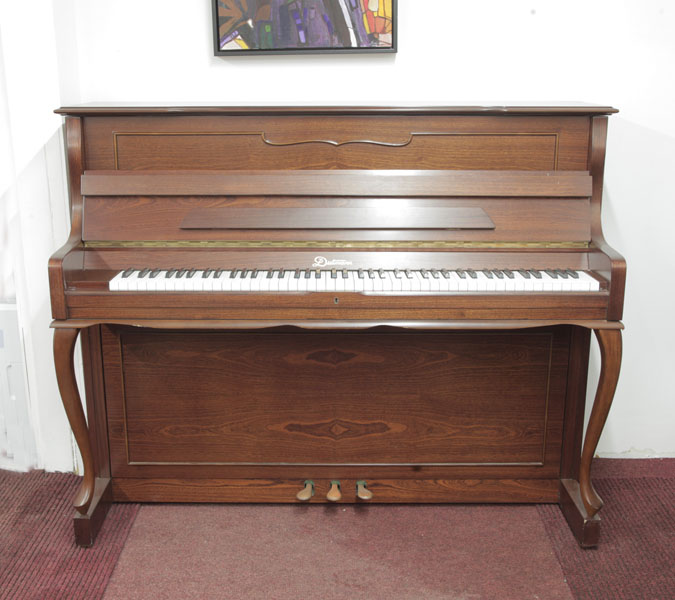 Dietmann upright piano with a walnut case and cabriole legs. Piano has an eighty-eight note keyboard and three pedals.