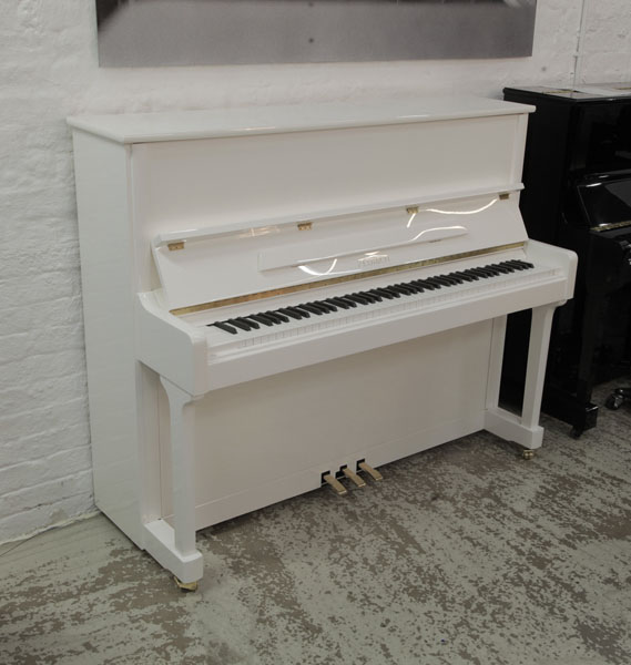 Brand new, Feurich Model 122 Universal upright piano in white gloss with brass fittings. Piano has an eighty-eight note keyboard and three pedals 