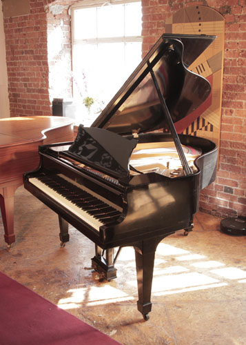 A 1925, Steinway Model S baby  grand piano with a black  case and spade legs. Piano has an eighty-eight note keyboard and a two-pedal lyre. 