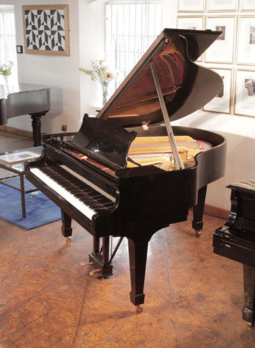 A 1951,  Steinway Model S baby  grand piano with a black  case and spade legs. Piano has an eighty-eight note keyboard and a two-pedal lyre. 